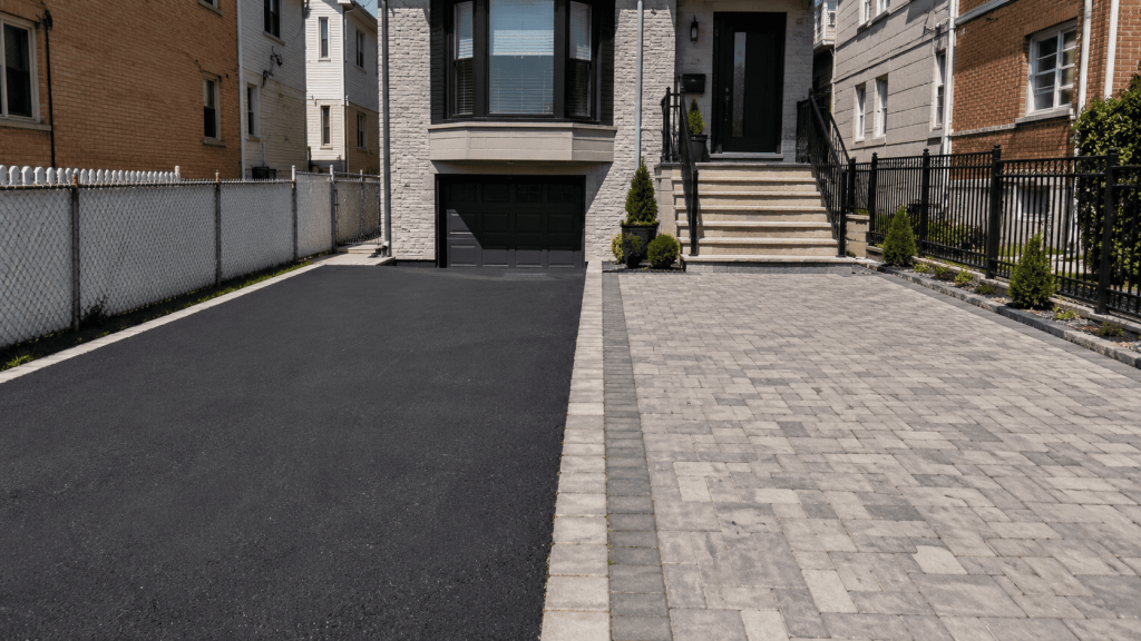 Side-by-side view of an asphalt driveway and an interlocking paver driveway at a New York City home, showing the two surface options homeowners often compare for cost and long-term value