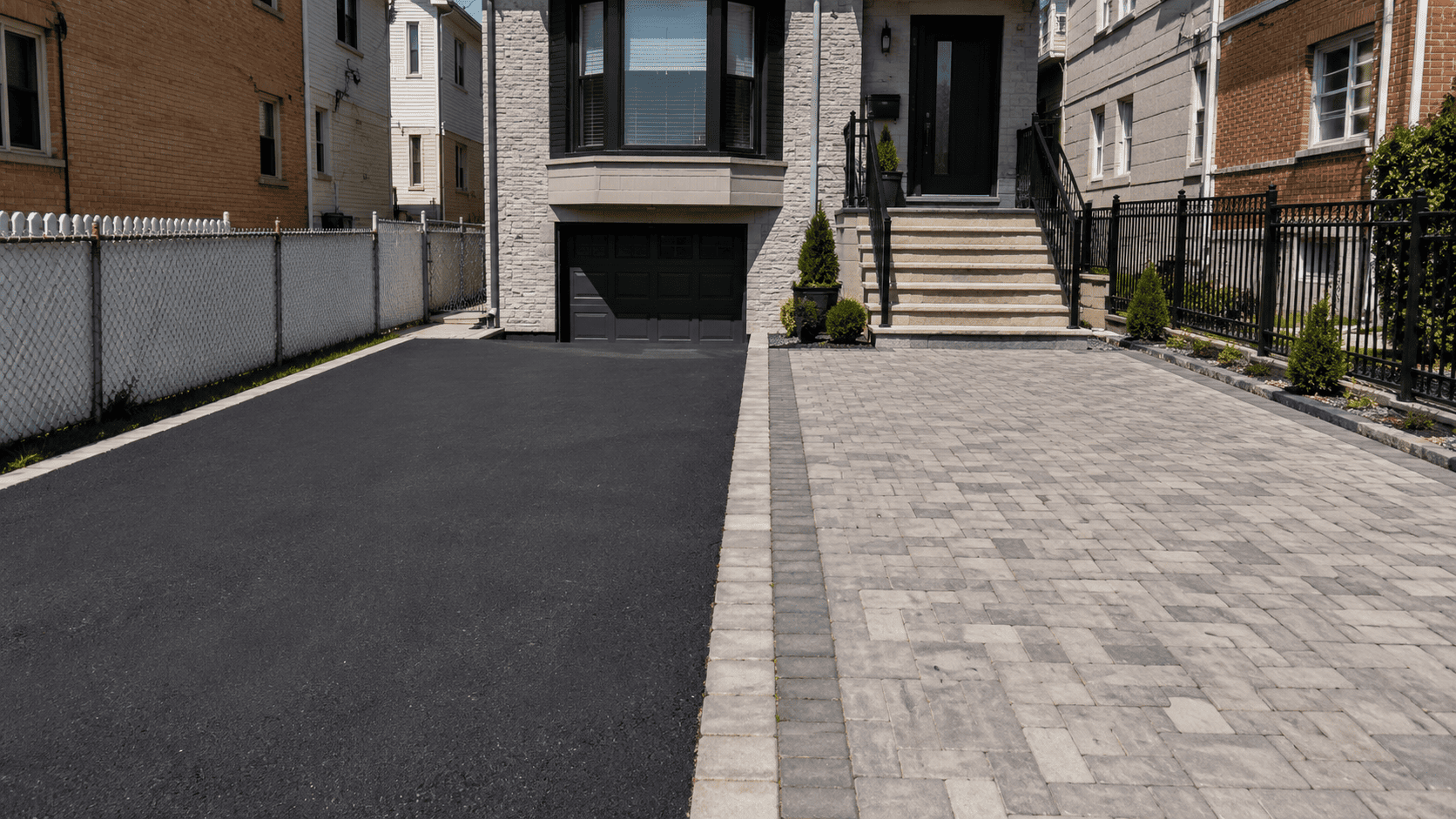 Side-by-side view of an asphalt driveway and an interlocking paver driveway at a New York City home, showing the two surface options homeowners often compare for cost and long-term value