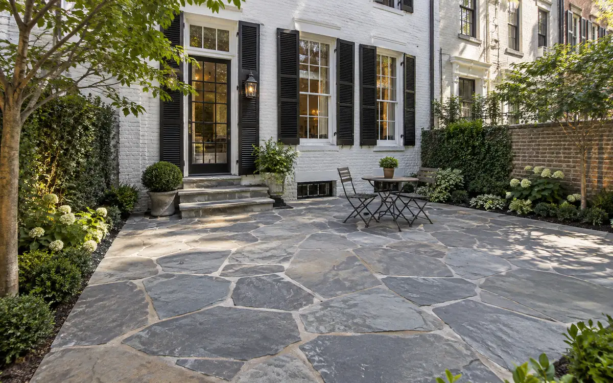 Irregular natural bluestone patio installed in a compact city backyard