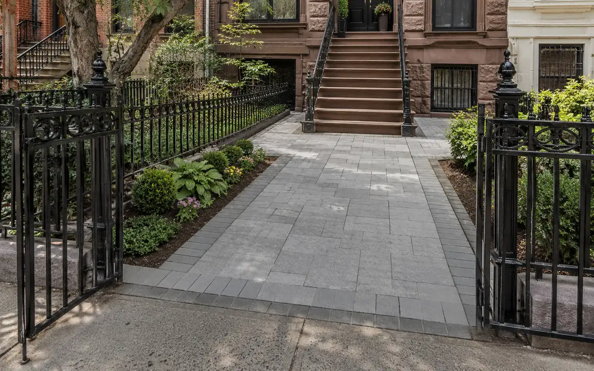 Concrete paver walkway leading to a Manhattan townhouse entrance