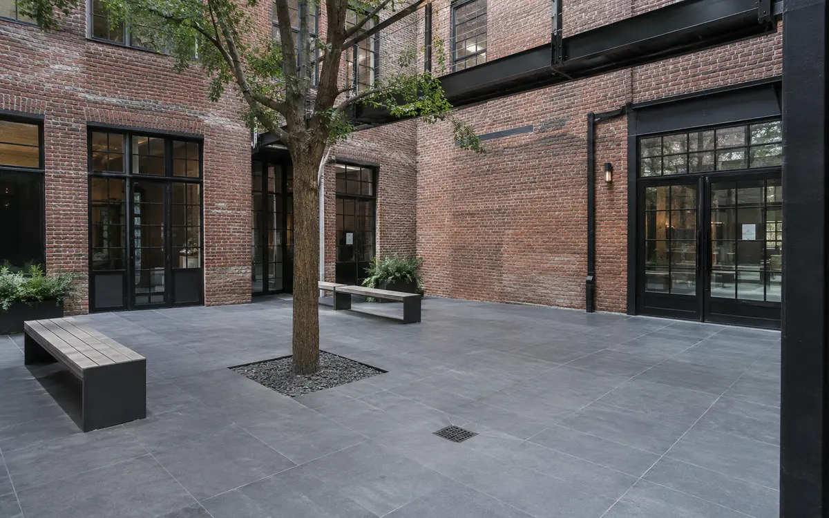 Large-format porcelain pavers installed in a landscaped townhouse courtyard