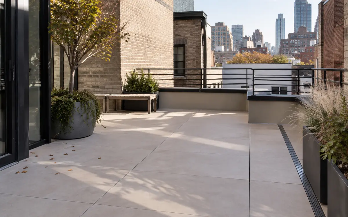 Large-format porcelain pavers installed beside a modern stone home