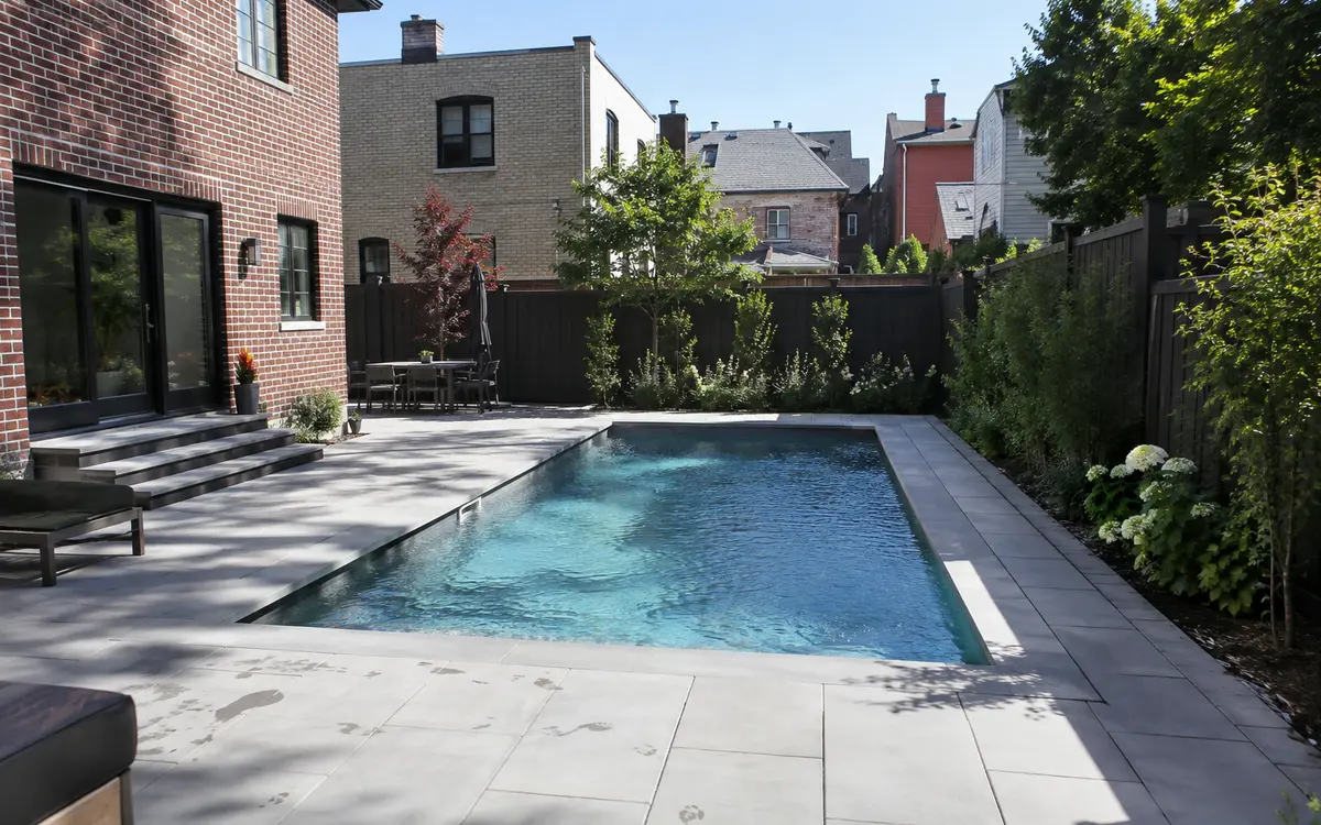 Light gray porcelain pavers installed around a modern residential swimming pool